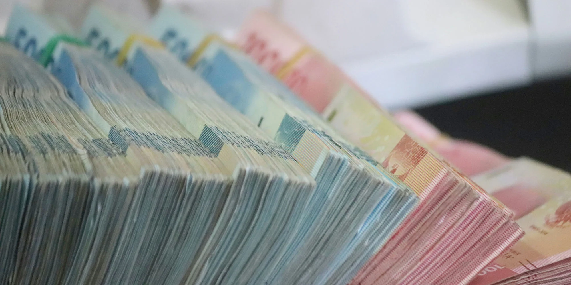 Apple didenda $851 juta karena pelanggaran privasi dan antimonopoli | Gambar menunjukkan tumpukan uang tunai dalam jumlah besar